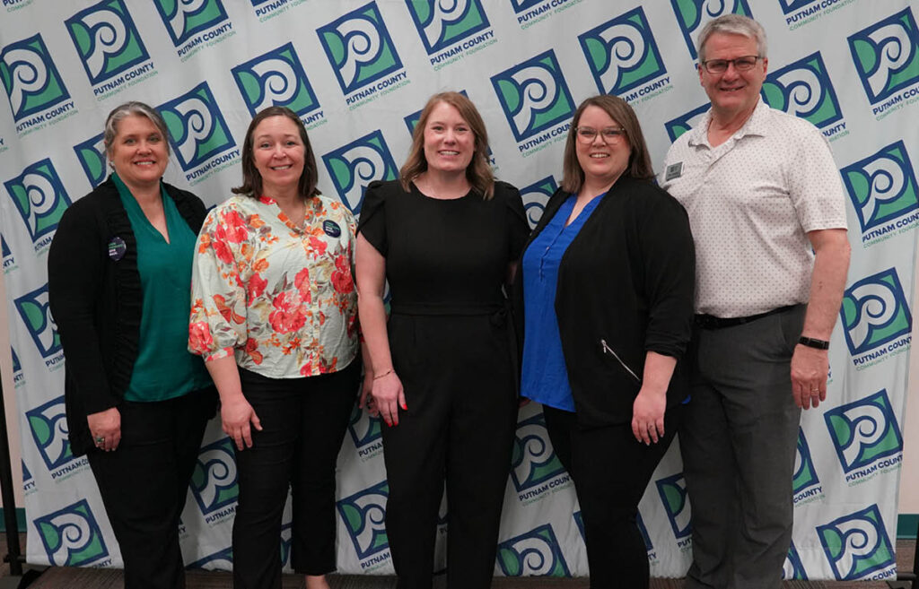 portrait of staff against Putnam logo wall