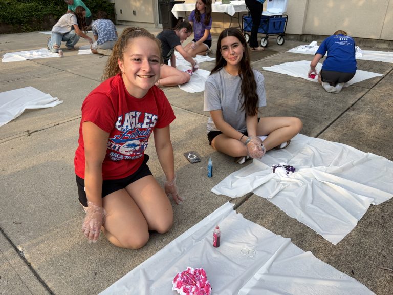 two girls making tie dye outdoors