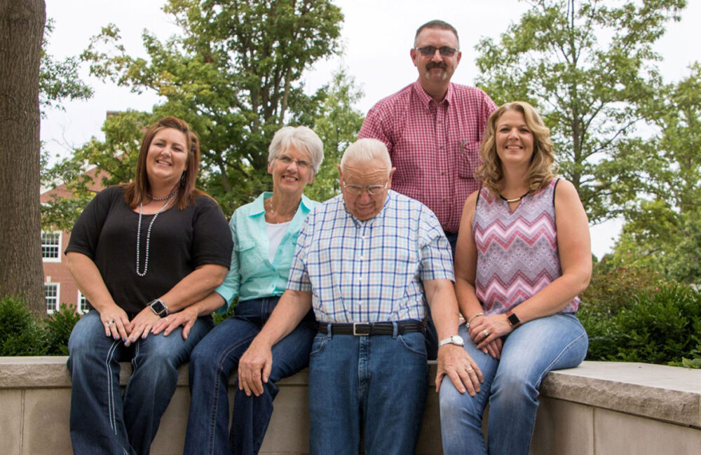 family portrait of five adults sitting outside
