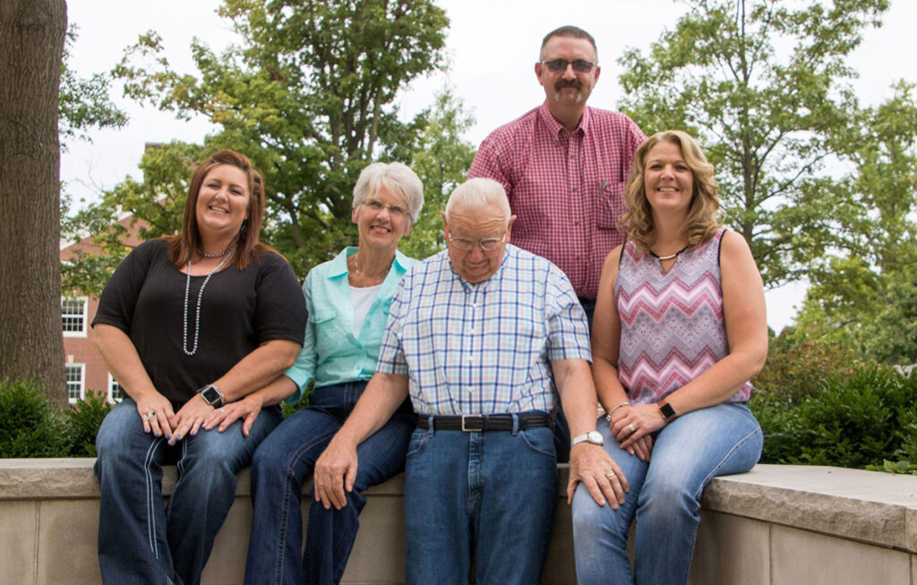 family portrait of five adults sitting outside